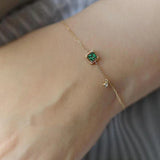 Armband mit grünem Kristall in Gold