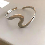 Offenes gewelltes Armband mit Drehung in Weißgold