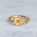 Rosa Retro-Ring mit goldenem Himmelsknoten
