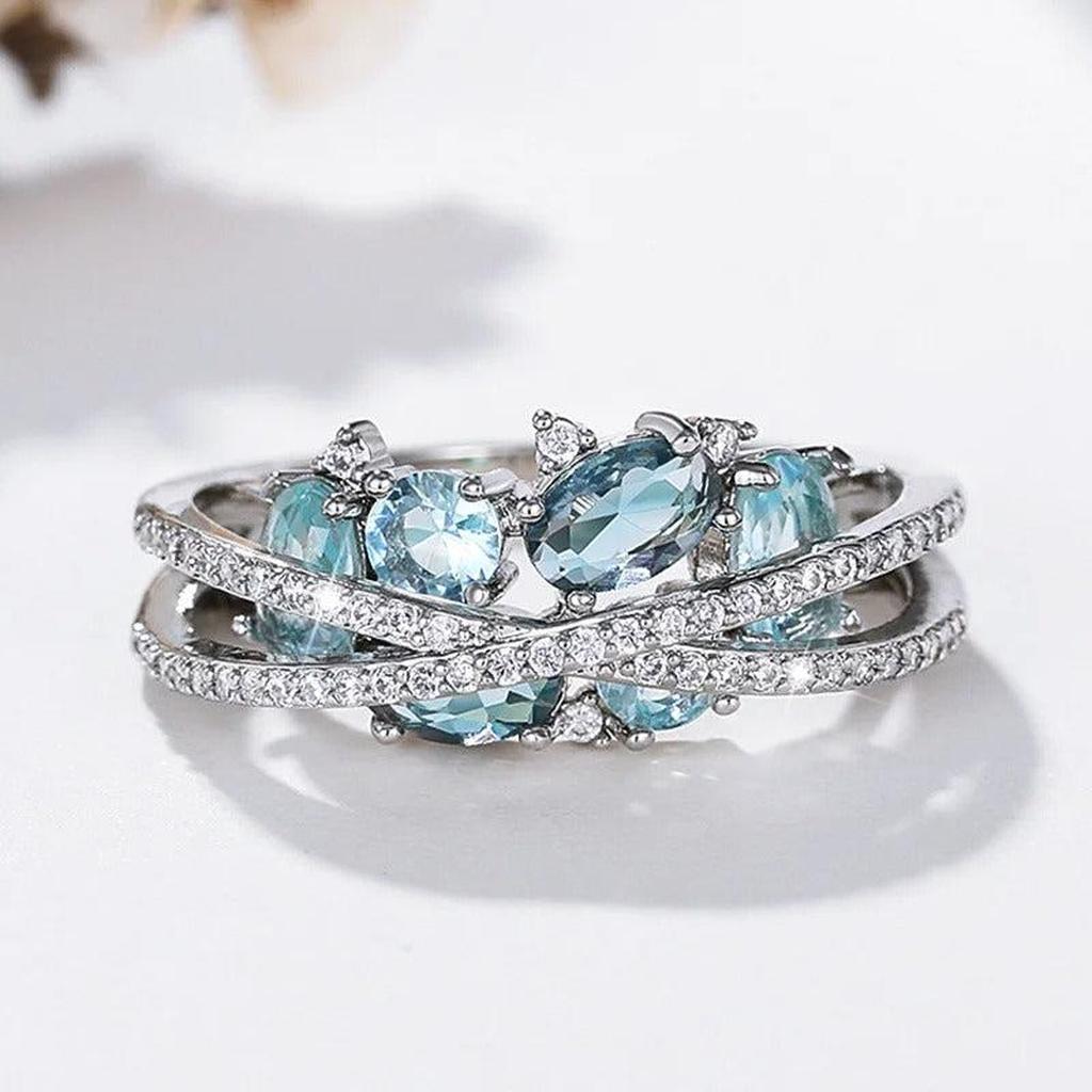 Ring mit Kreuz in Weißgold und blauem Stein