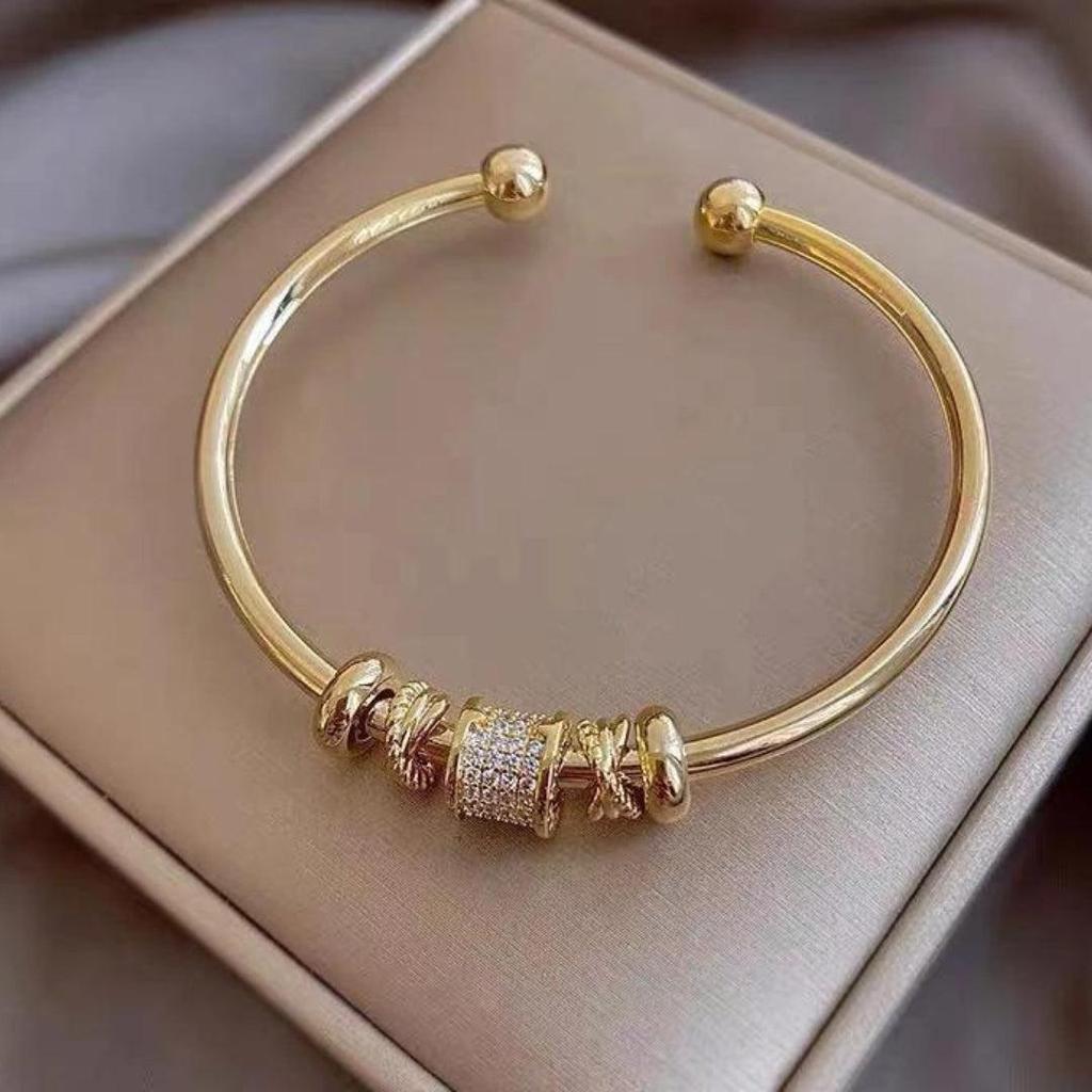 Verstellbares Armband mit goldenen Anhängern